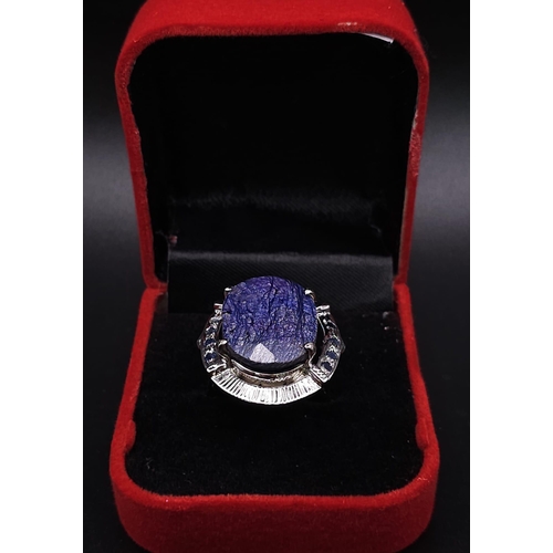 584 - A Blue Sapphire and 925 Silver Ring. Oval cut central sapphire with small sapphire accents. Size R. ... 