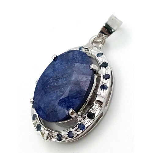 723 - A Blue Sapphire and 925 Sterling Silver Pendant. Oval sapphire with a small sapphire stone surround.... 