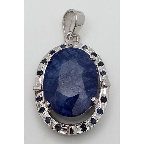 723 - A Blue Sapphire and 925 Sterling Silver Pendant. Oval sapphire with a small sapphire stone surround.... 