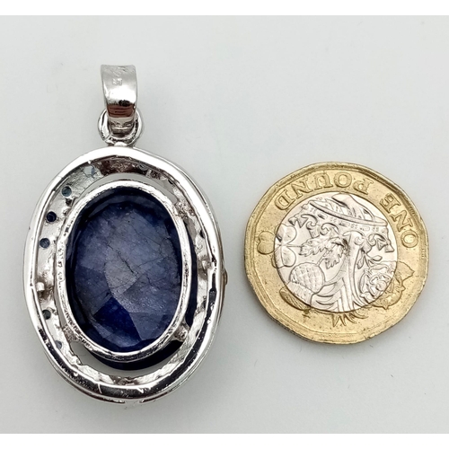 723 - A Blue Sapphire and 925 Sterling Silver Pendant. Oval sapphire with a small sapphire stone surround.... 