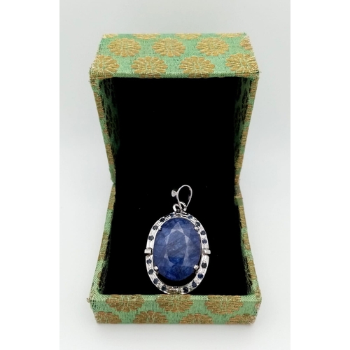 723 - A Blue Sapphire and 925 Sterling Silver Pendant. Oval sapphire with a small sapphire stone surround.... 