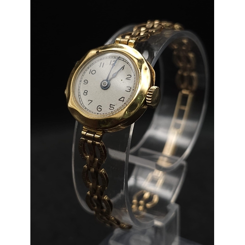 548 - A VINTAGE 18K GOLD LADIES WRISTWATCH ON AN ORNATE 9K GOLD STRAP , GOOD WORKING ORDER . 15.2gms