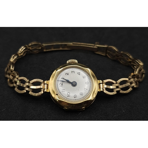 548 - A VINTAGE 18K GOLD LADIES WRISTWATCH ON AN ORNATE 9K GOLD STRAP , GOOD WORKING ORDER . 15.2gms