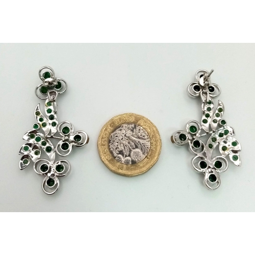 563 - A Pair of Emerald Floral Drop Earrings. Set in 925 sterling silver. Emeralds - 11.50ctw. 11g total w... 