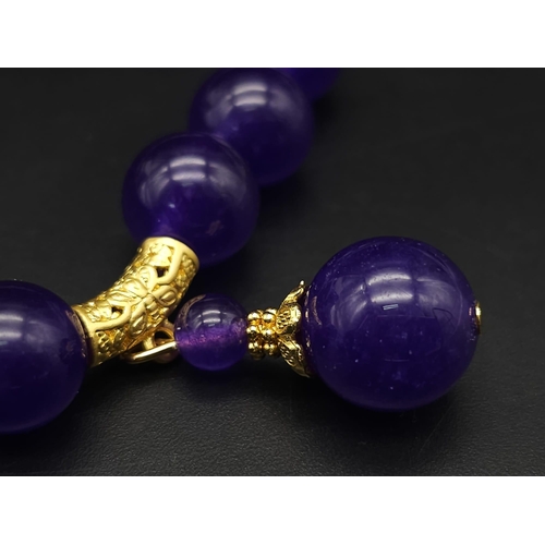 576 - A Purple Jade with Hanging Purple Jade Pendant. Gilded accents and clasp. 44cm necklace length. 12mm... 