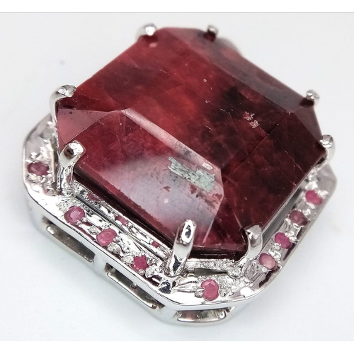 317 - An Octagon-Cut 128ct Ruby and 925 Silver Pendant. Large central stone with ruby surround. 4.5cm. 43.... 