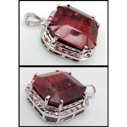 317 - An Octagon-Cut 128ct Ruby and 925 Silver Pendant. Large central stone with ruby surround. 4.5cm. 43.... 