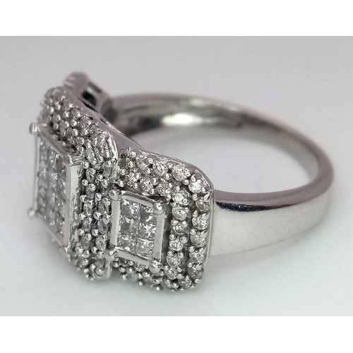 739 - An Art Deco Style 18K White Gold and Diamond Ring. A belt-buckle design of round and princess cut di... 