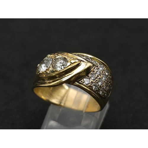 933 - An 18kt Yellow Gold Ring with a duo of Round Cut Diamonds on one side, offset by a pavement of diamo... 