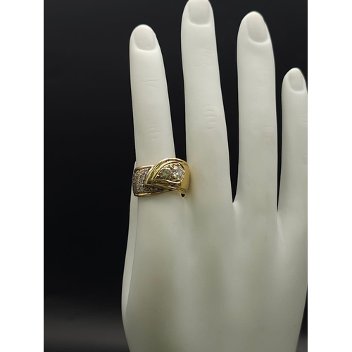 933 - An 18kt Yellow Gold Ring with a duo of Round Cut Diamonds on one side, offset by a pavement of diamo... 