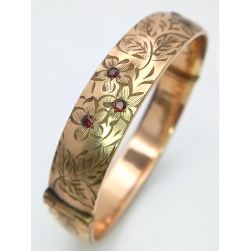 8 - A vintage 9 K yellow gold engraved bangle with round cut garnets , width: 12.8 mm, weight: 22.4 g. E... 