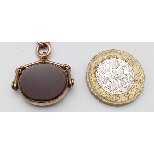 386 - A 9 K rose gold revolving fob with a flat bloodstone cabochon on one side and a carnelian on the oth... 