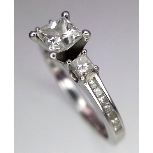 505 - A DESIGNER PLATINUM AND DIAMOND RING WITH SQUARE CENTRAL DIAMOND AND HAVING DIAMONDS TO EACH SHOULDE... 