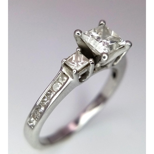 505 - A DESIGNER PLATINUM AND DIAMOND RING WITH SQUARE CENTRAL DIAMOND AND HAVING DIAMONDS TO EACH SHOULDE... 