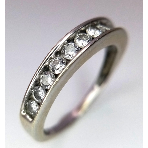 701 - A 14K WHITE GOLD RING WITH CHANNEL SET DIAMONDS .   2.6gms    size O      10437