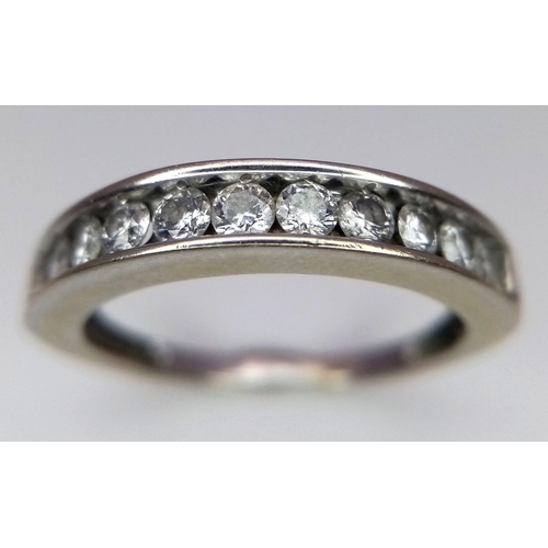 701 - A 14K WHITE GOLD RING WITH CHANNEL SET DIAMONDS .   2.6gms    size O      10437