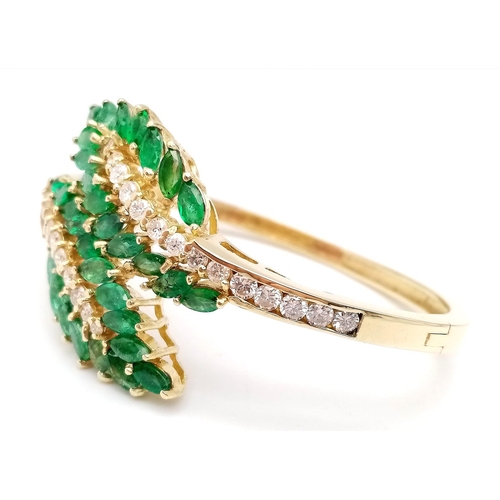 10 - A DIAMOND AND EMERALD LEAF DESIGN BANGLE IN CROSSOVER STYLE SET IN18K GOLD .    33.5gms     10457