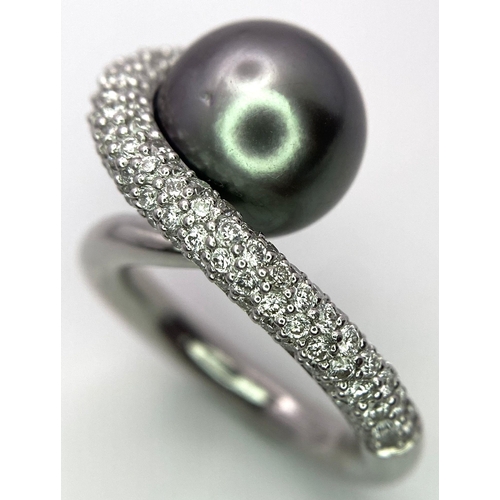 715 - A BEUTIFUL SOUTH SEA PEARL SET IN A SWIRL DESIGN IN 18K WHITE GOLD AND DIAMONDS .  12.8gms   size M ... 