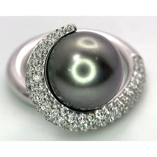 715 - A BEUTIFUL SOUTH SEA PEARL SET IN A SWIRL DESIGN IN 18K WHITE GOLD AND DIAMONDS .  12.8gms   size M ... 