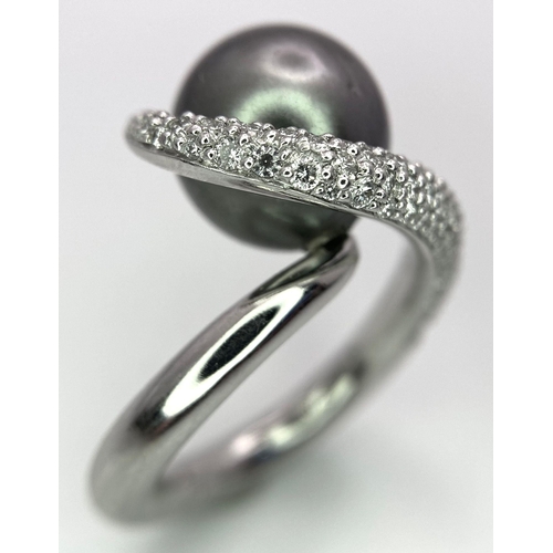 715 - A BEUTIFUL SOUTH SEA PEARL SET IN A SWIRL DESIGN IN 18K WHITE GOLD AND DIAMONDS .  12.8gms   size M ... 