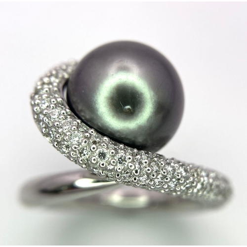 715 - A BEUTIFUL SOUTH SEA PEARL SET IN A SWIRL DESIGN IN 18K WHITE GOLD AND DIAMONDS .  12.8gms   size M ... 