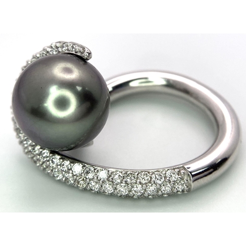 715 - A BEUTIFUL SOUTH SEA PEARL SET IN A SWIRL DESIGN IN 18K WHITE GOLD AND DIAMONDS .  12.8gms   size M ... 