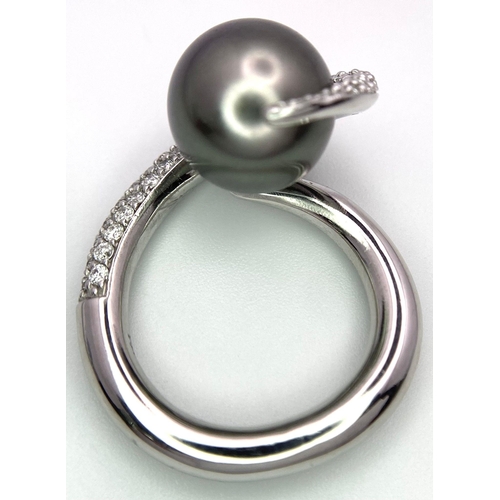 715 - A BEUTIFUL SOUTH SEA PEARL SET IN A SWIRL DESIGN IN 18K WHITE GOLD AND DIAMONDS .  12.8gms   size M ... 