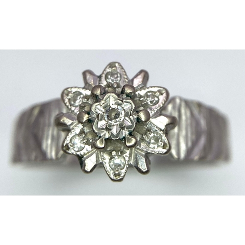10 - A Vintage 18K White Gold Diamond Floral Ring. Ridged effect on shoulders. Size L/M. 3.36g total weig... 