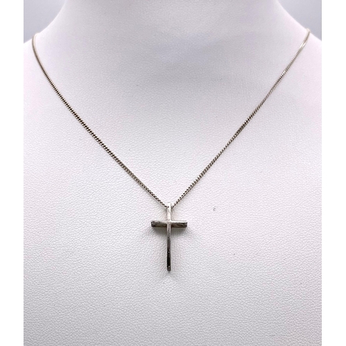 749 - A STERLING SILVER CROSS PENDANT ON A 46cms SILVER CHAIN .   3.3gms