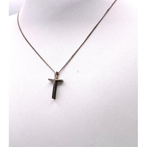 749 - A STERLING SILVER CROSS PENDANT ON A 46cms SILVER CHAIN .   3.3gms