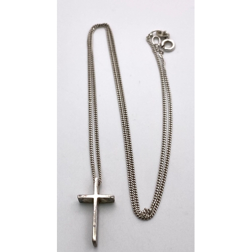 749 - A STERLING SILVER CROSS PENDANT ON A 46cms SILVER CHAIN .   3.3gms