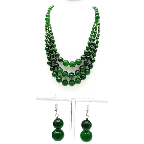 384 - An Oriental green jade necklace, with one to three strands and earrings set. Necklace Length: 50 cm,... 