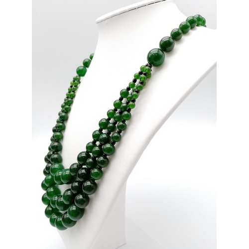 384 - An Oriental green jade necklace, with one to three strands and earrings set. Necklace Length: 50 cm,... 