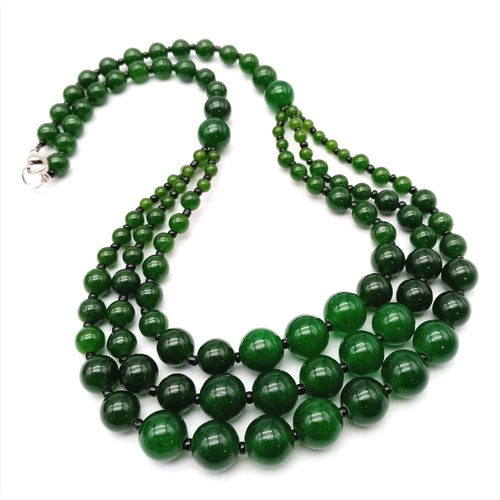 384 - An Oriental green jade necklace, with one to three strands and earrings set. Necklace Length: 50 cm,... 