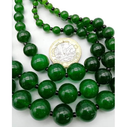 384 - An Oriental green jade necklace, with one to three strands and earrings set. Necklace Length: 50 cm,... 