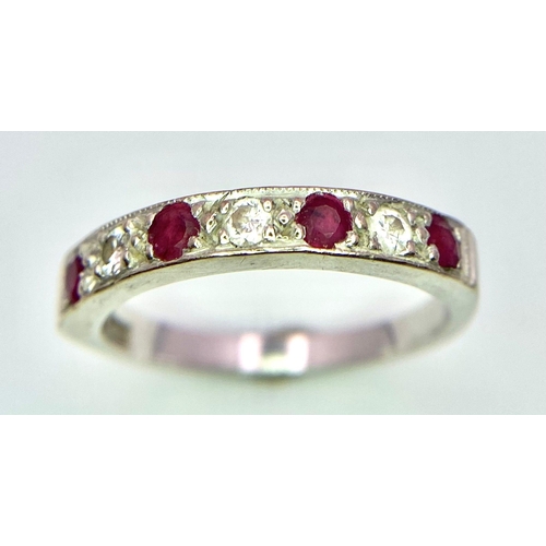 767 - A Vintage 18K White Gold, Ruby and Diamond Ring. Four rubies and diamonds almost reaching half-etern... 