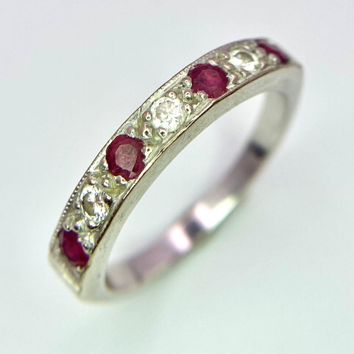 767 - A Vintage 18K White Gold, Ruby and Diamond Ring. Four rubies and diamonds almost reaching half-etern... 