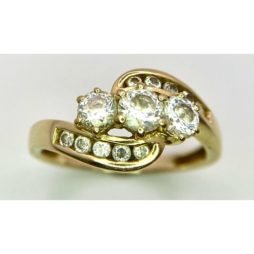 155 - A 14K Yellow Gold Diamond Crossover Ring. Three round cut diamonds engulfed in diamond waves. Size Q... 