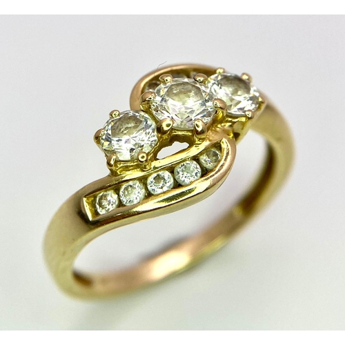 155 - A 14K Yellow Gold Diamond Crossover Ring. Three round cut diamonds engulfed in diamond waves. Size Q... 
