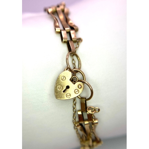 171 - A Vintage 9K Yellow Gold 'Bow Tie' Gate Bracelet - with heart clasp and safety chain. 16cm. 6.75g we... 