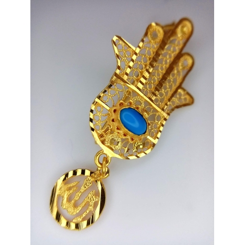 445 - An 18K Yellow Gold 'Hand of God' Brooch. Turquoise cabochon decoration. 4.5cm. 3.5g total weight.