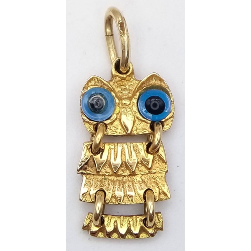 386 - A 14k yellow gold articulated owl pendant with glass evil eye detailing (2.5cm height) 3.2g