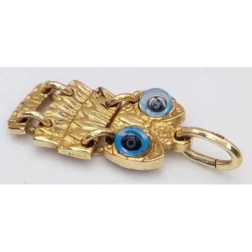 386 - A 14k yellow gold articulated owl pendant with glass evil eye detailing (2.5cm height) 3.2g