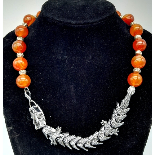 125 - An unusual, Oriental, carnelian necklace with a white metal (untested) large Chinese dragon clasp, a... 