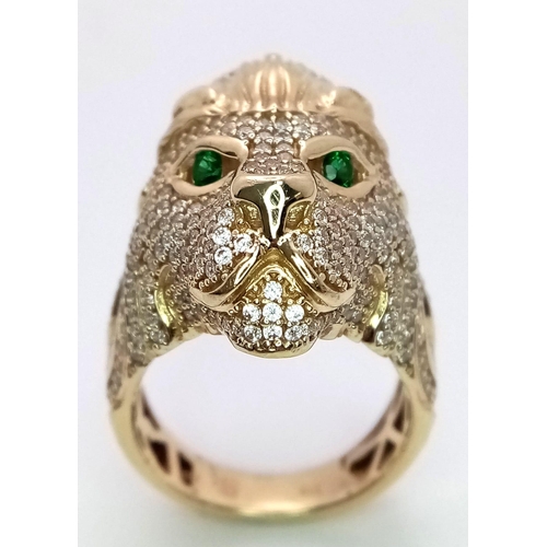 79 - A 9K YELLOW GOLD STONE SET LIONS HEAD RING. 11.5G. SIZE T