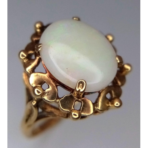 1344 - A Vintage 9K Yellow Gold Opal Ring. Central oval opal cabochon with colour-play set in a raised foun... 