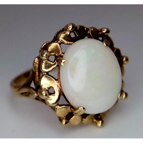 1344 - A Vintage 9K Yellow Gold Opal Ring. Central oval opal cabochon with colour-play set in a raised foun... 