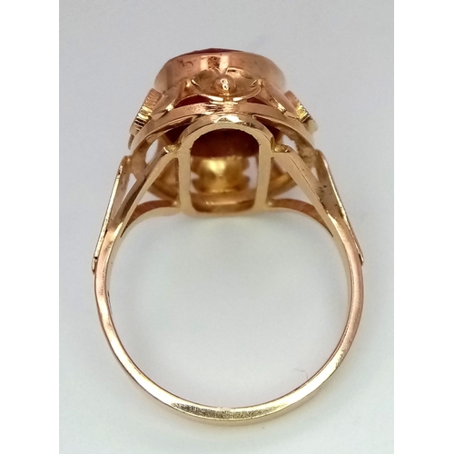 353 - A Vintage 18K Yellow Gold Ruby Ring. Central faceted oval ruby (5ct) in a raised decorative scroll f... 