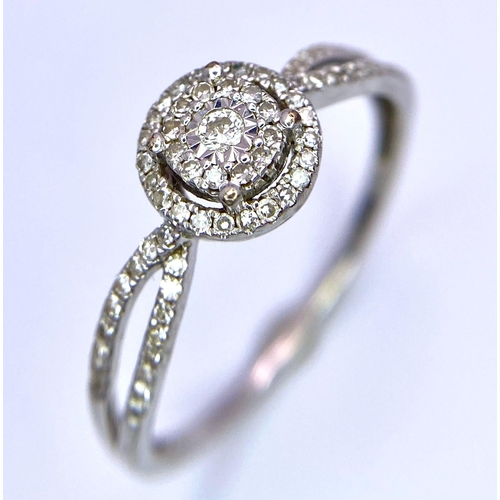 116 - A 9K White Gold Diamond Double Halo Ring. Central diamond with double diamond halo and shoulder acce... 