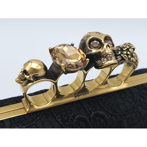 265 - Alexander McQueen Skull & Gem Ring Clutch.
Black floral embroidered exterior with gold tone hardware... 